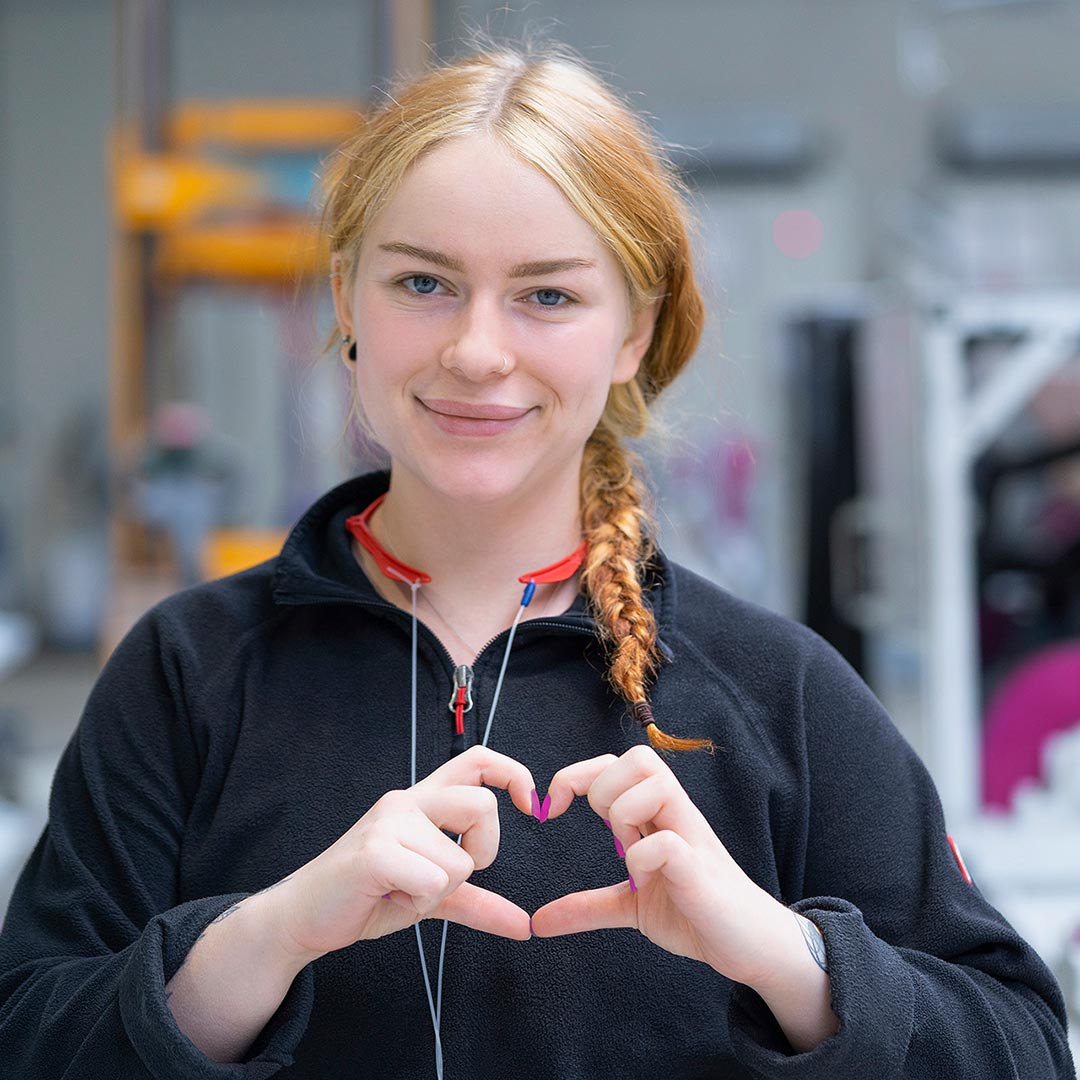 _fuchs_gewerblich_ausbildung_GFK Junge Frau zeigt mit ihren Händen ein Herz in die Kamera